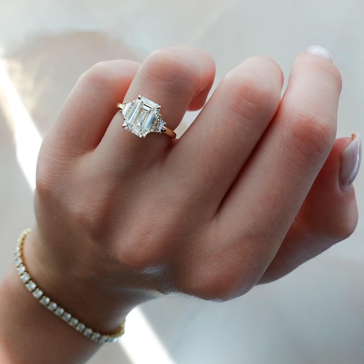 Three Stone ring with Trapezoid side diamonds and an Emerald cut